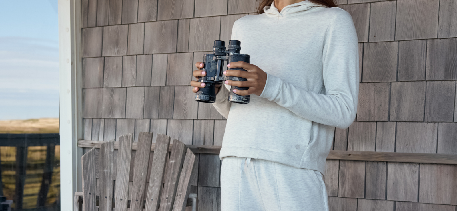 woman wearing Free Fly holding binoculars